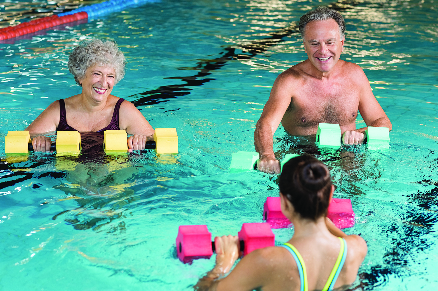 Seniors using water weights in the pool