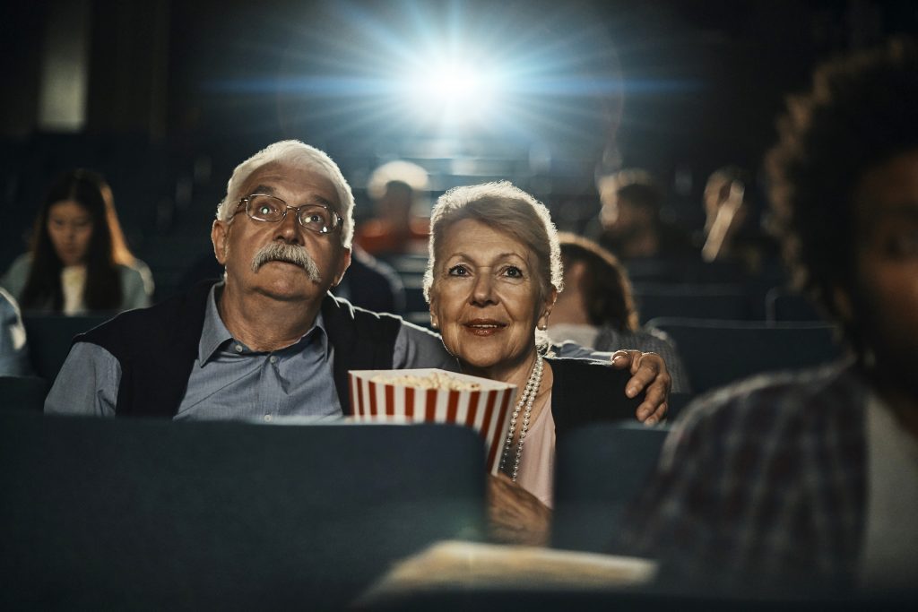 Close up of a senior couple captivated by a movie in the cinema