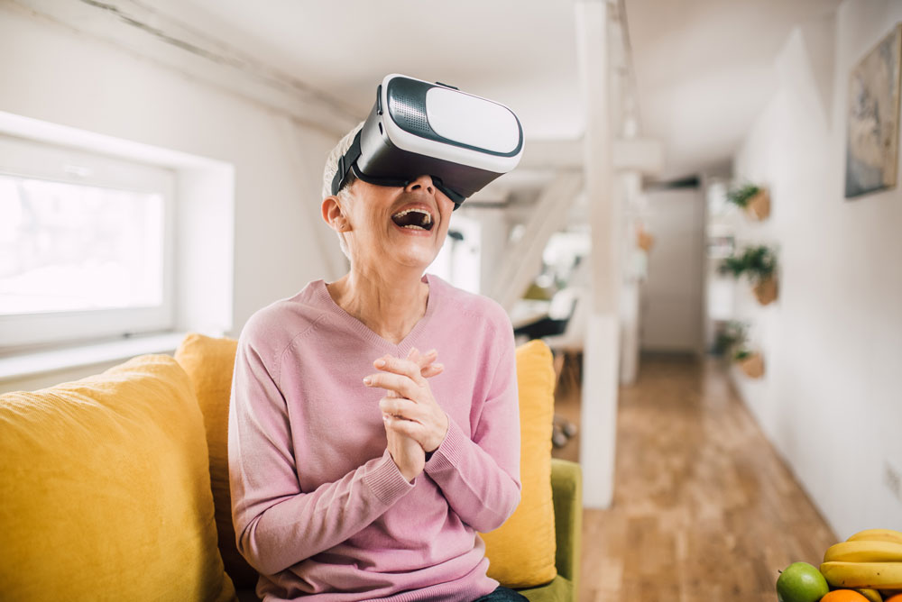 Woman demonstrates benefits of technology for seniors and uses virtual reality headset.